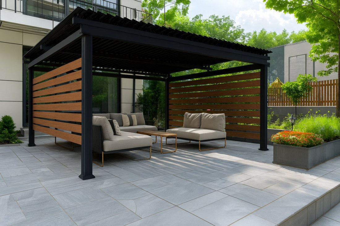 Black aluminum louvered pergola with woodgrain slat privacy panels over an outdoor sectional on a stone patio